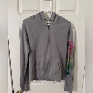 PINK Victoria’s Secret Zip Up Hoodie, with Colorful lettering down the sleeve.